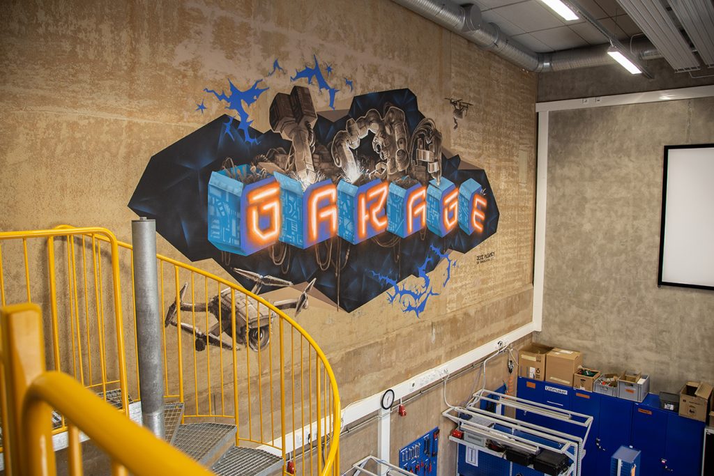 Metropolian Robo Garage kuvattuna yläkerrasta, tilan seinässä Robo Garage -grafittiteos.
